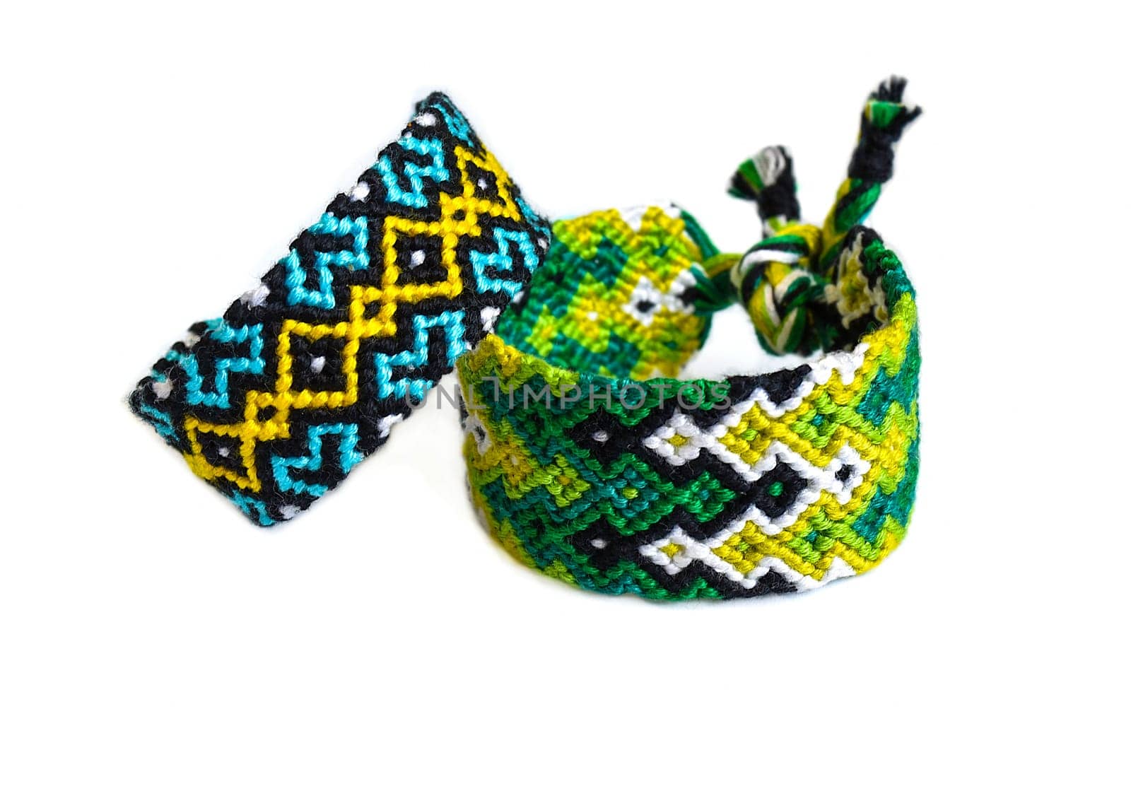 Multicolored woven DIY friendship bracelets handmade of embroidery bright thread with knots isolated on white background