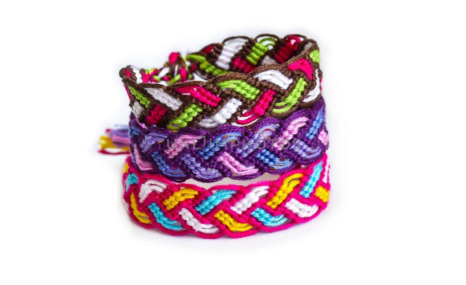 Multicolored woven DIY friendship bracelets handmade of embroidery bright thread with knots isolated on white background