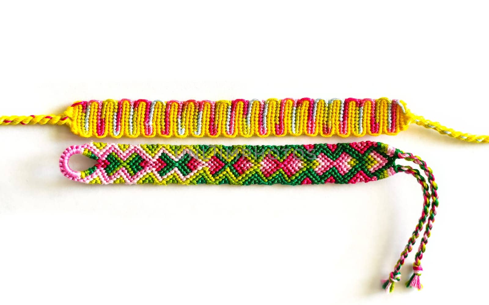 Multicolored woven DIY friendship bracelets handmade of embroidery bright thread with knots isolated on white backgroundMulticolored woven DIY friendship bracelets handmade of embroidery bright thread with knots isolated on white background