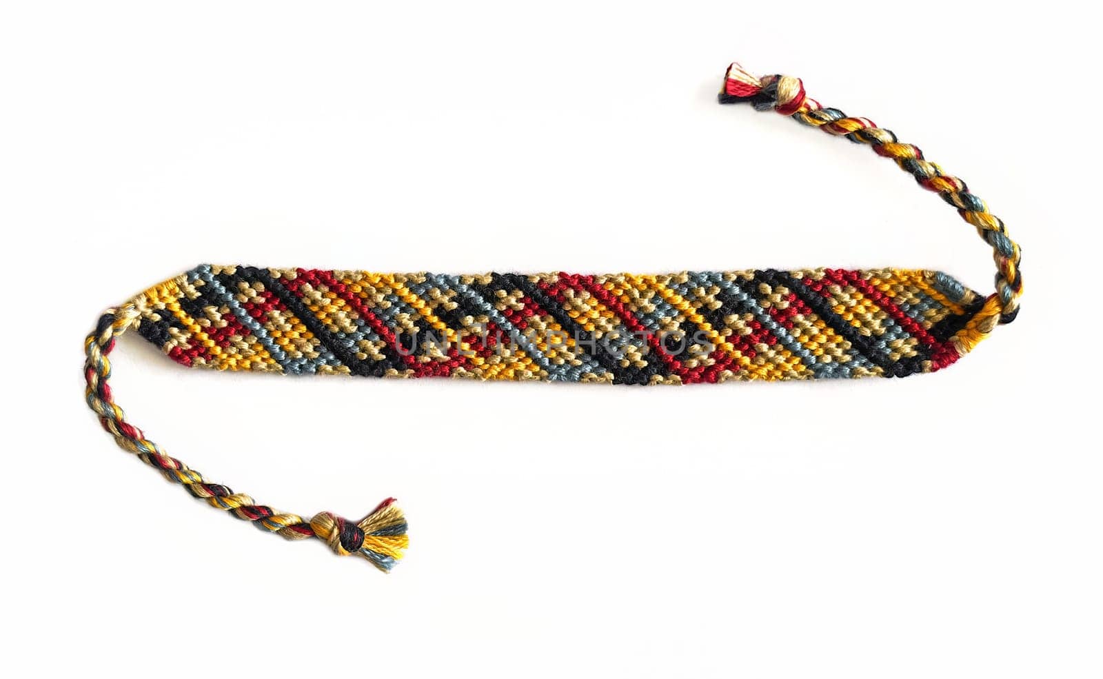 Multicolored woven DIY friendship bracelets handmade of embroidery bright thread with knots isolated on white backgroundMulticolored woven DIY friendship bracelets handmade of embroidery bright thread with knots isolated on white background