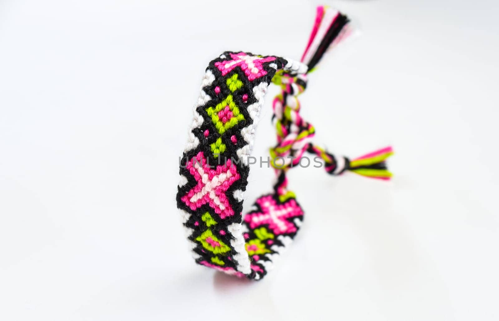 Multicolored woven DIY friendship bracelets handmade of embroidery bright thread with knots isolated on white background