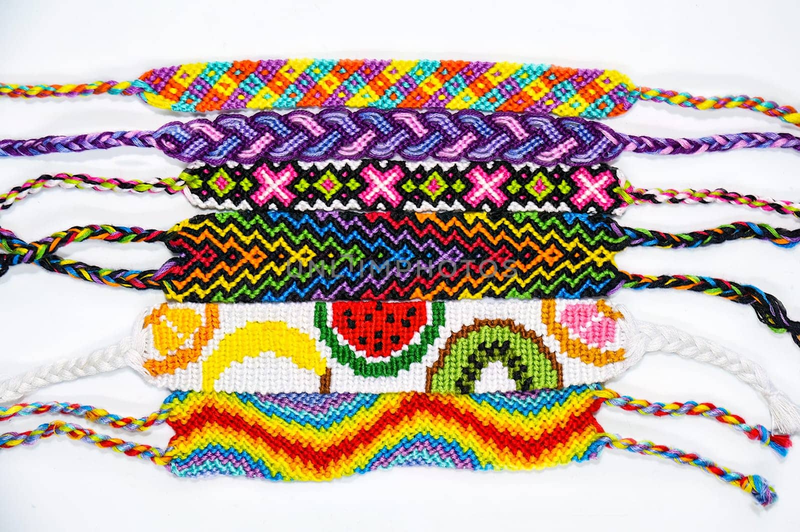 Multicolored woven DIY friendship bracelets handmade of embroidery bright thread with knots isolated on white background