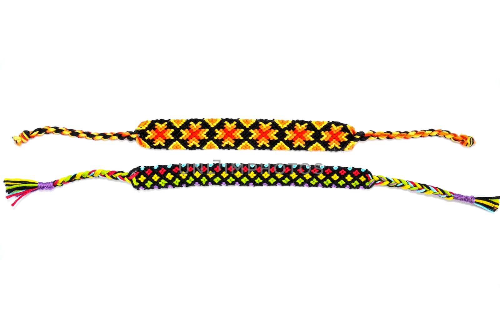 Multicolored woven DIY friendship bracelets handmade of embroidery bright thread with knots isolated on white background