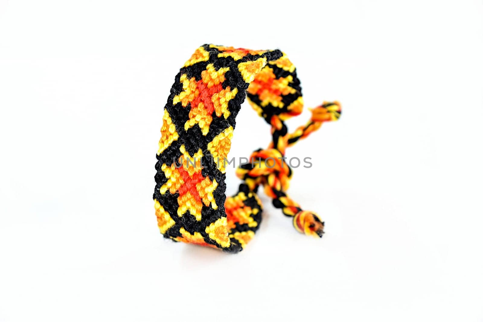 Multicolored woven DIY friendship bracelets handmade of embroidery bright thread with knots isolated on white background