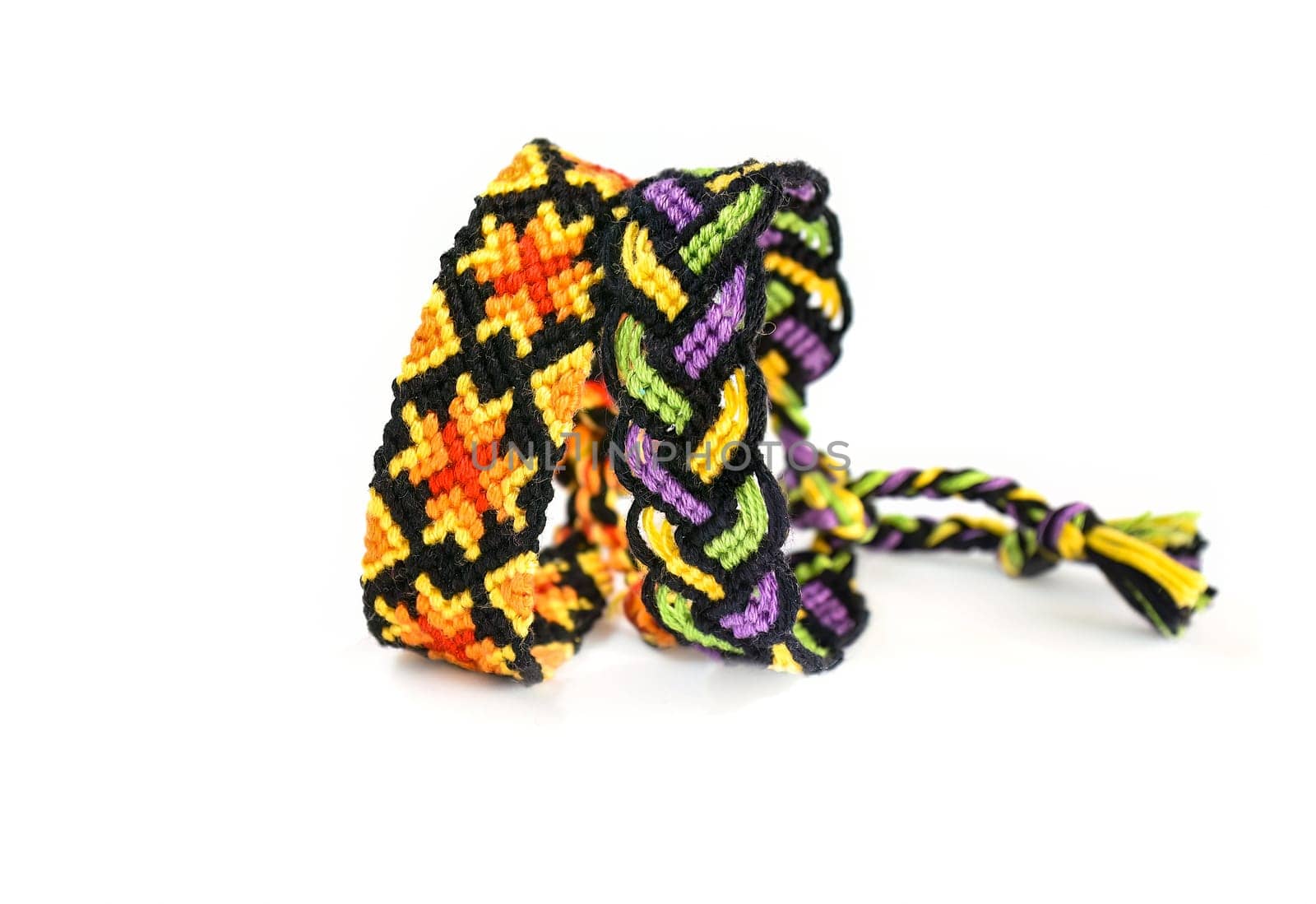 Multicolored woven DIY friendship bracelets handmade of embroidery bright thread with knots isolated on white background