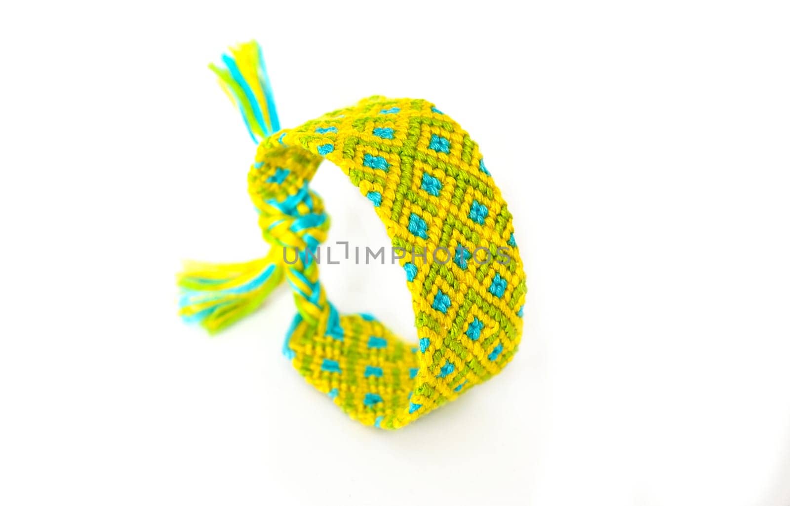 Multicolored woven DIY friendship bracelets handmade of embroidery bright thread with knots isolated on white background