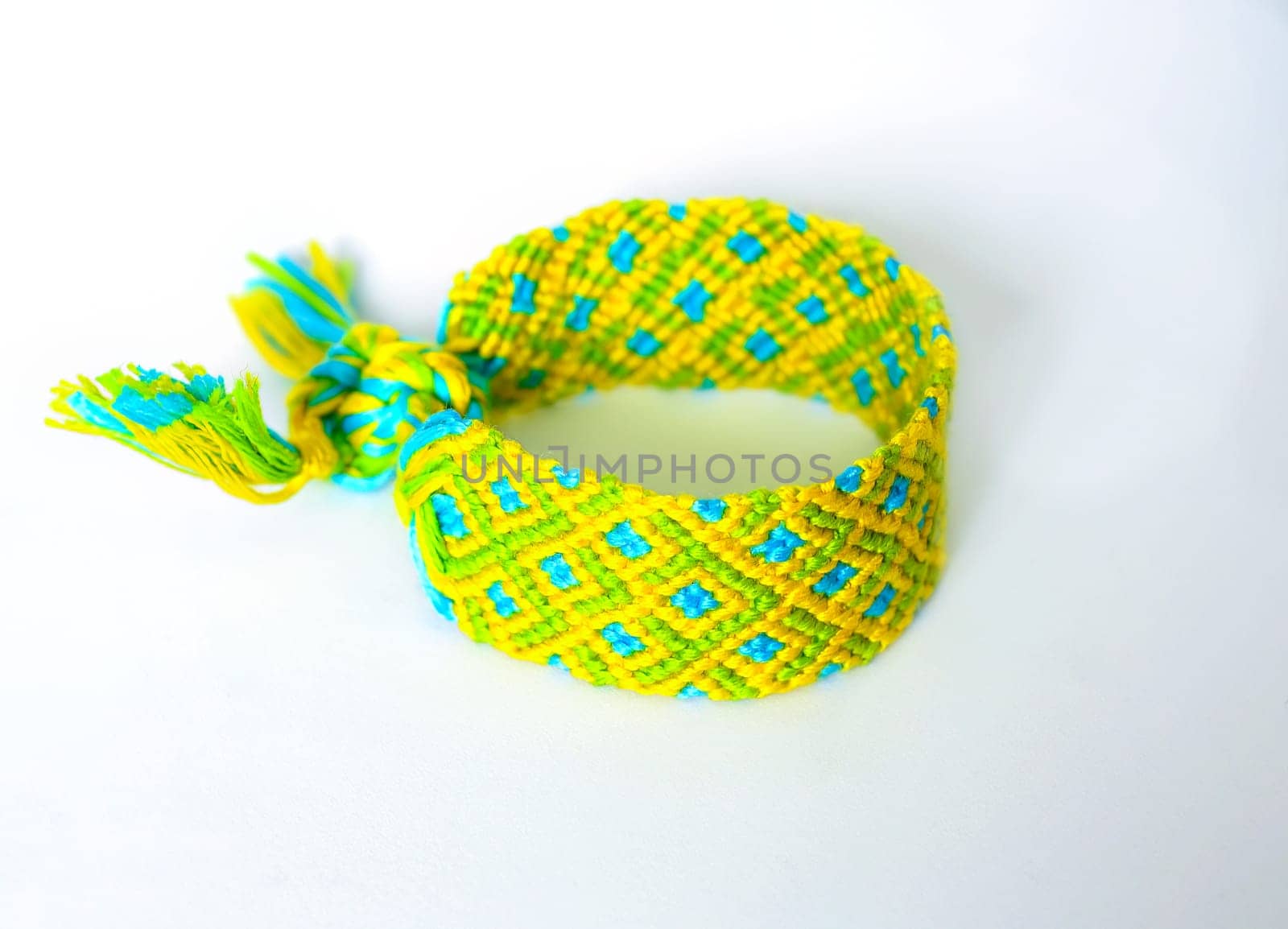 Multicolored woven DIY friendship bracelets handmade of embroidery bright thread with knots isolated on white background