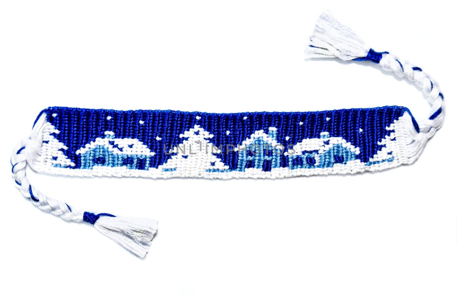 Woven friendship bracelet with Christmas alpha pattern Snowy night with houses. Handmade of thread, isolated on white background. New Year DIY gift idea