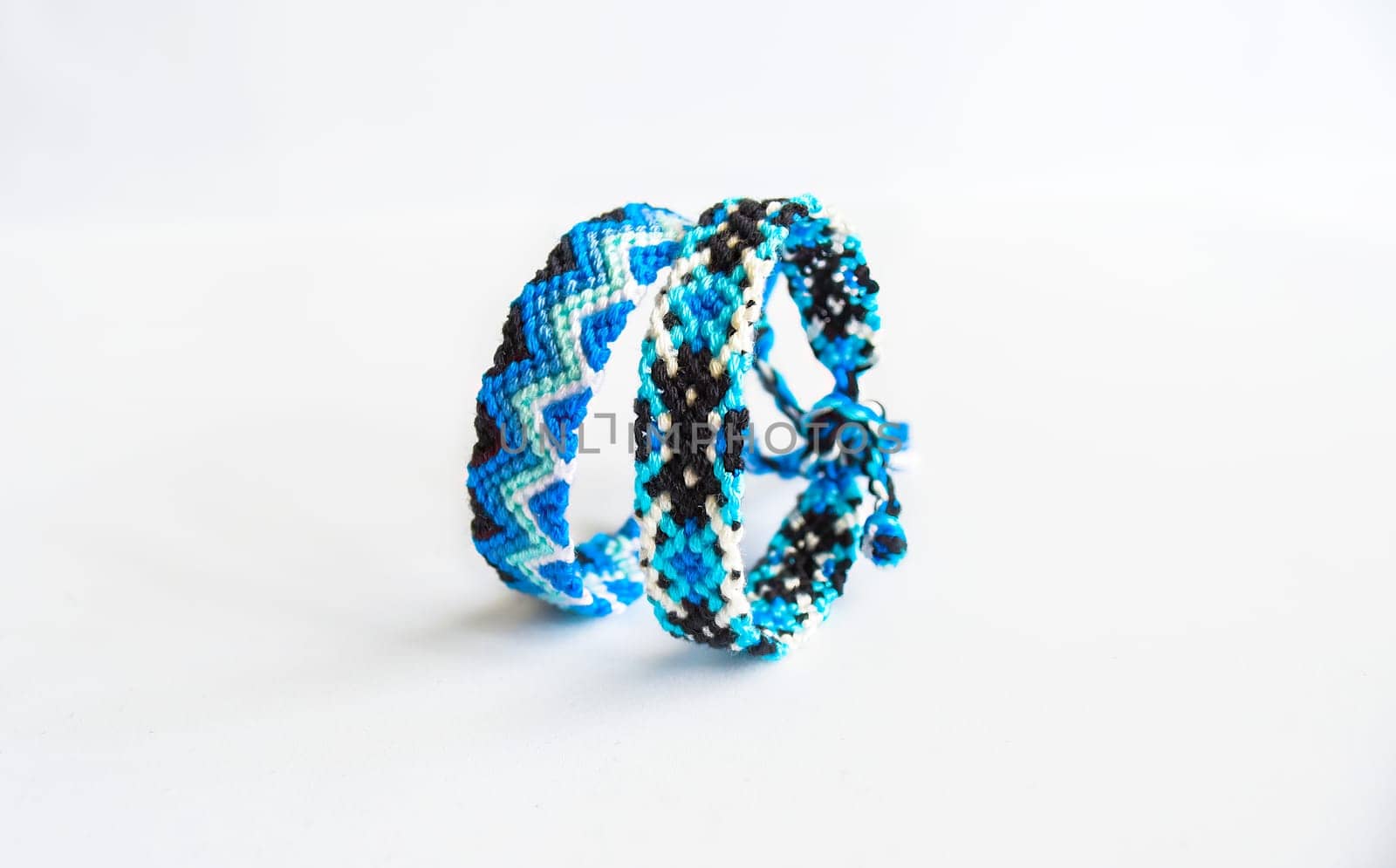 Multicolored woven DIY friendship bracelets handmade of embroidery bright thread with knots isolated on white background