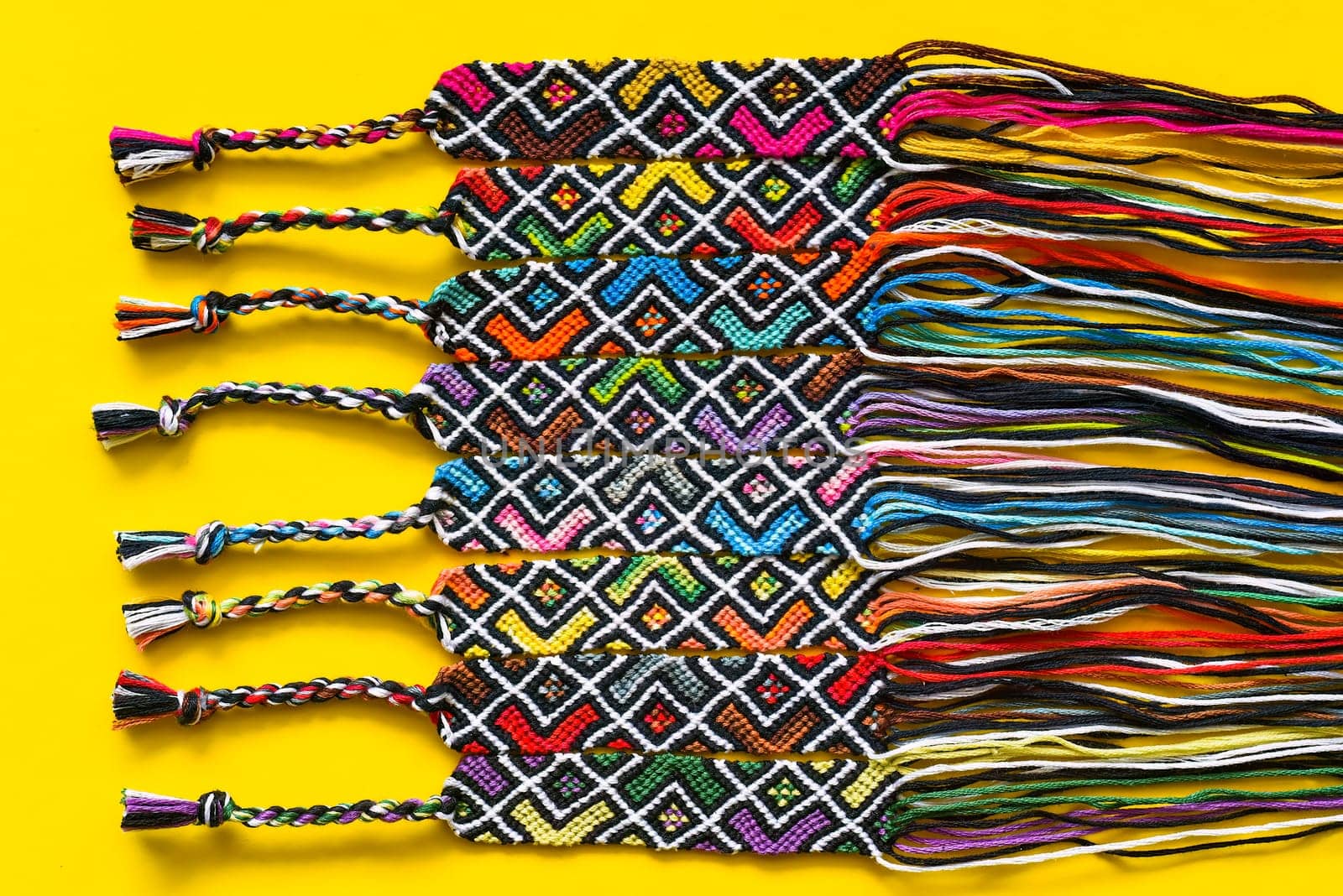 Unfinished DIY woven friendship bracelets with abstract geometric pattern. Summer accessories