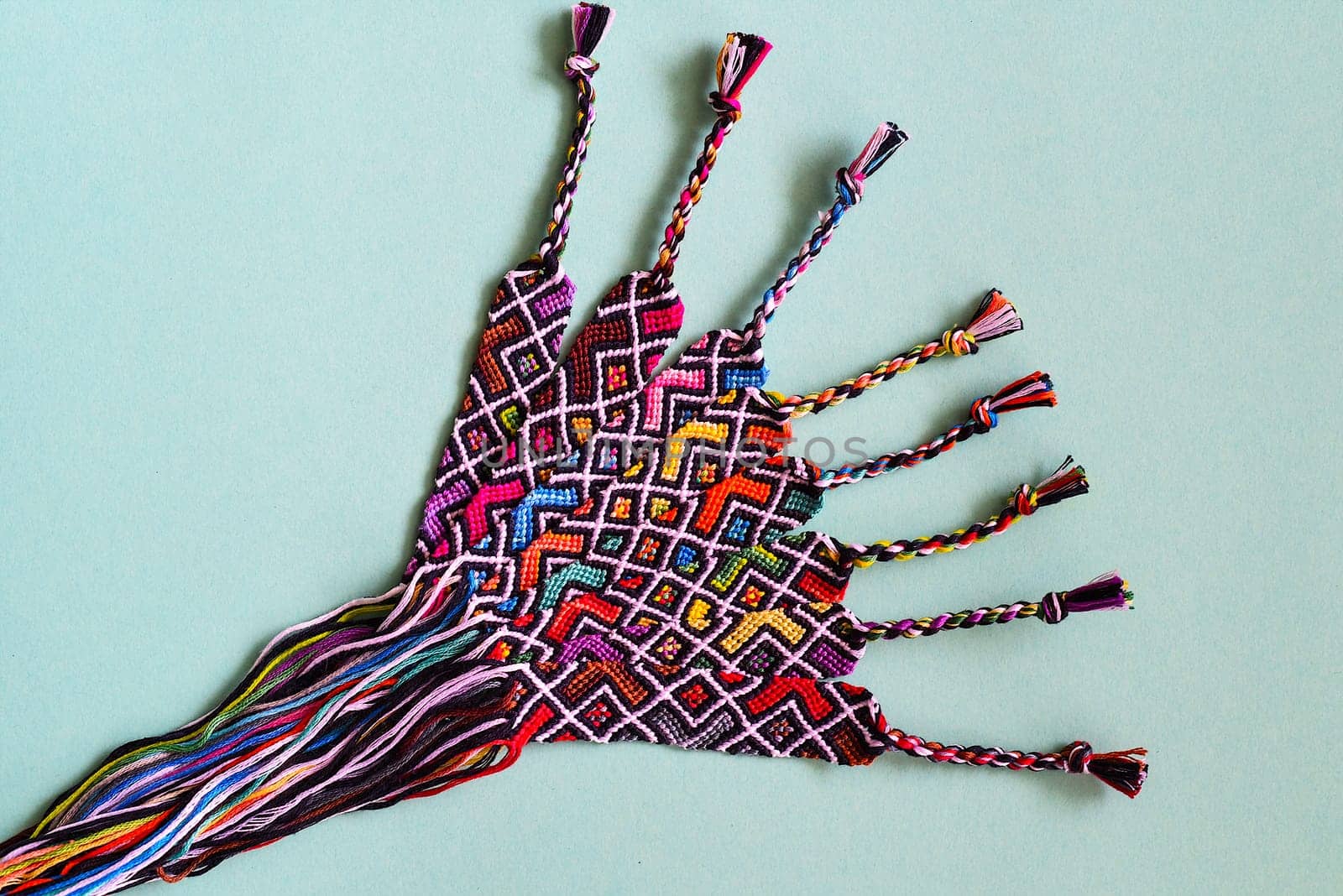 Unfinished DIY woven friendship bracelets with abstract geometric pattern. Summer accessories
