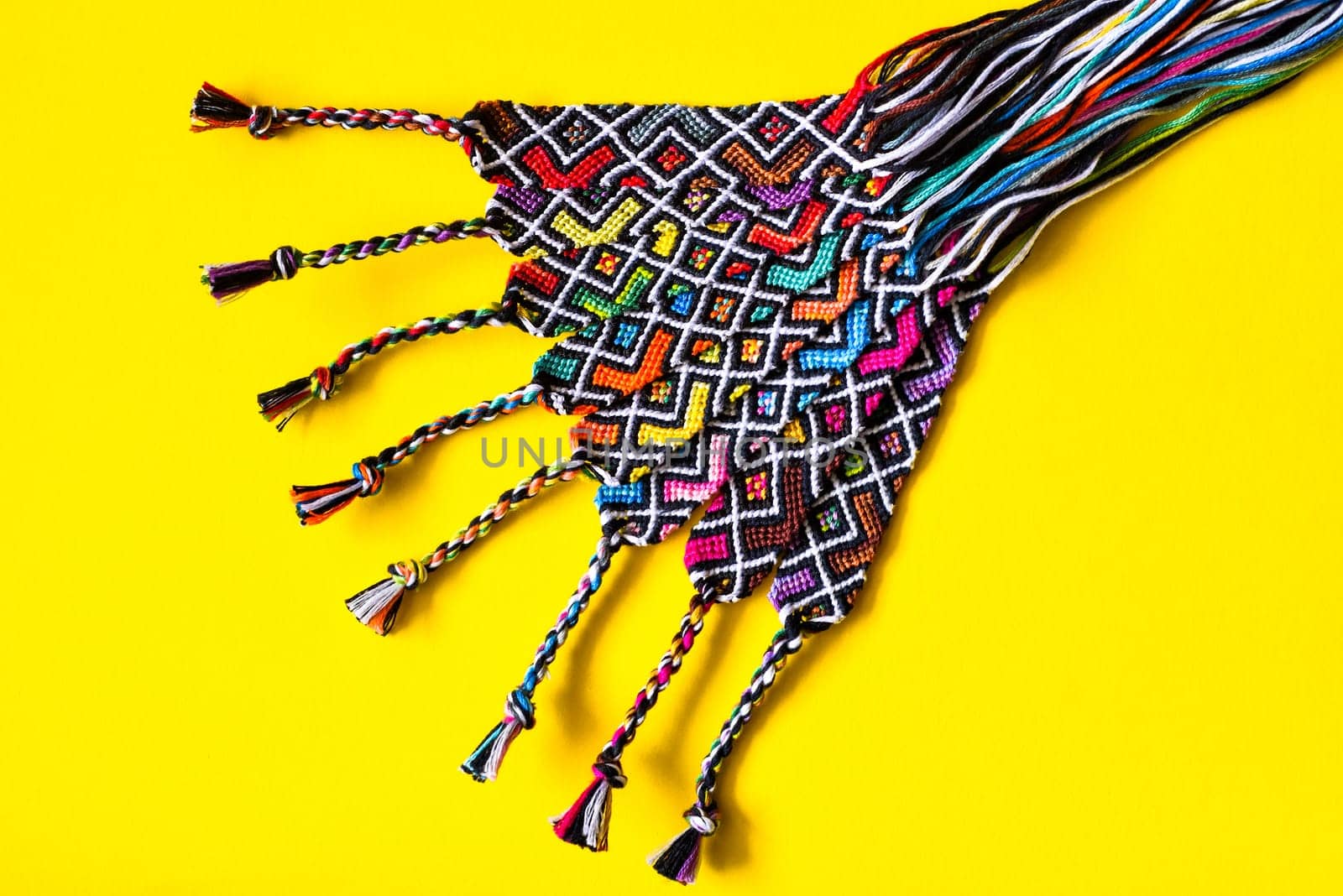 Unfinished DIY woven friendship bracelets with abstract geometric pattern. Summer accessories