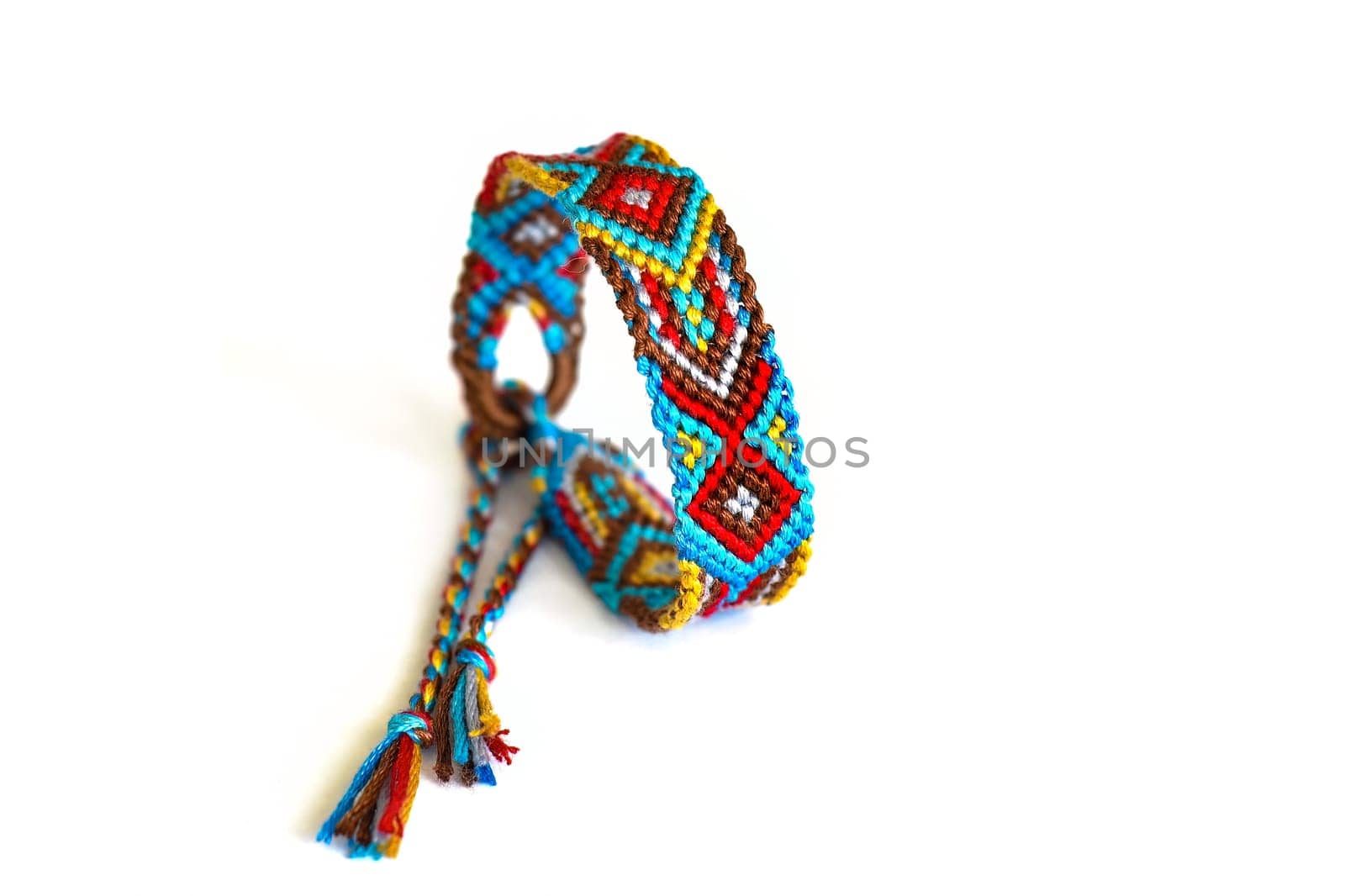 Multicolored woven DIY friendship bracelets handmade of embroidery bright thread with knots isolated on white background