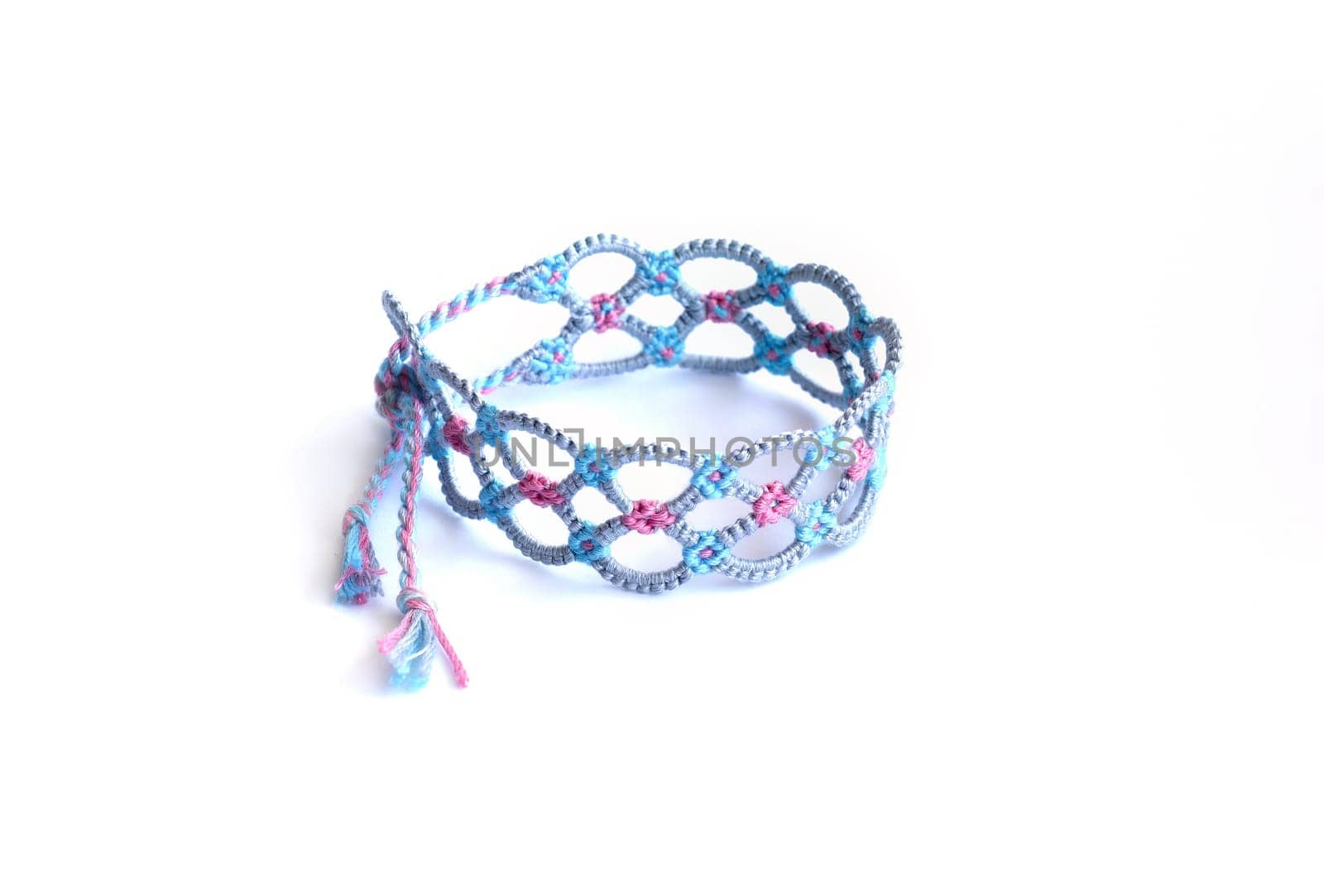 Multicolored woven DIY friendship bracelets handmade of embroidery bright thread with knots isolated on white background