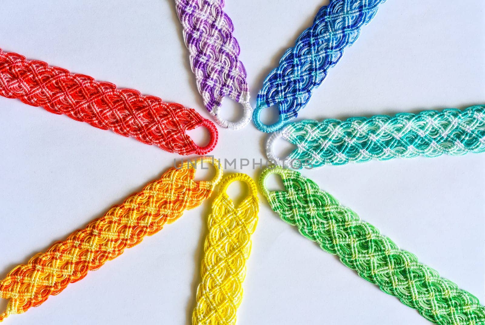 Multicolored woven DIY friendship bracelets handmade of embroidery bright thread with knots isolated on white background