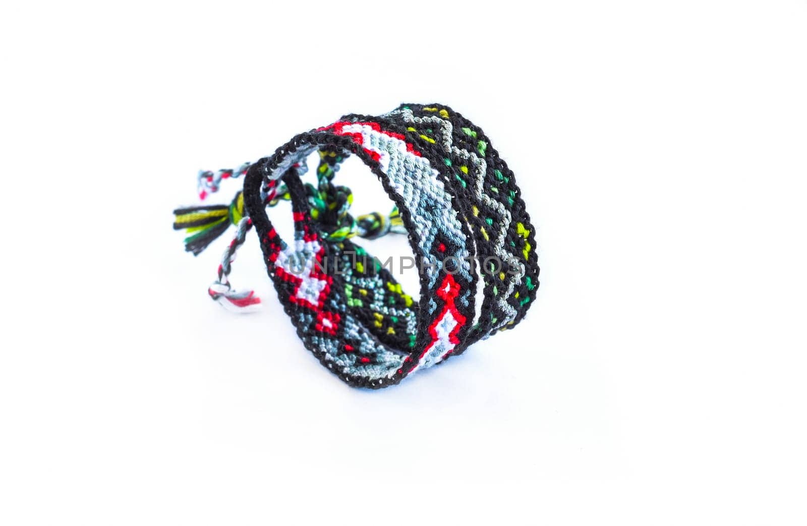 Multicolored woven DIY friendship bracelets handmade of embroidery bright thread with knots isolated on white background