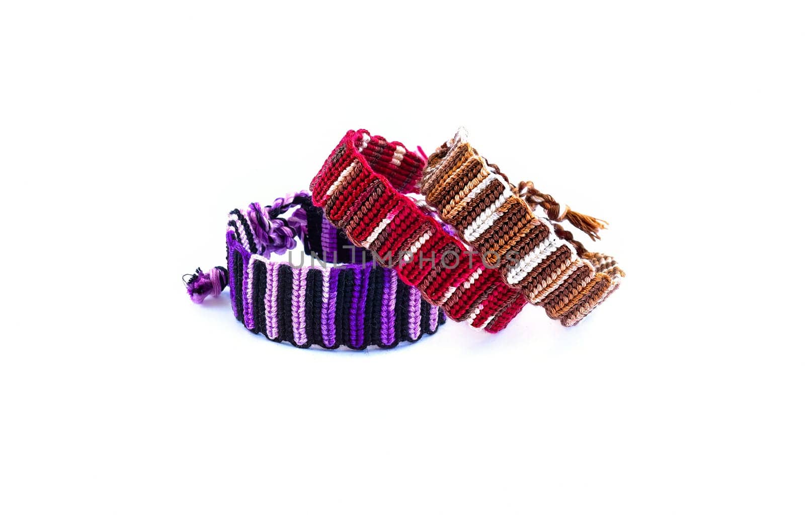 Multicolored woven DIY friendship bracelets handmade of embroidery bright thread with knots isolated on white background