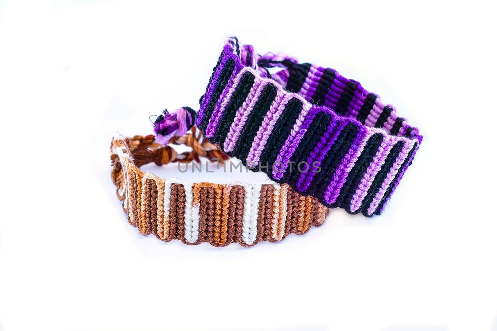Multicolored woven DIY friendship bracelets handmade of embroidery bright thread with knots isolated on white background