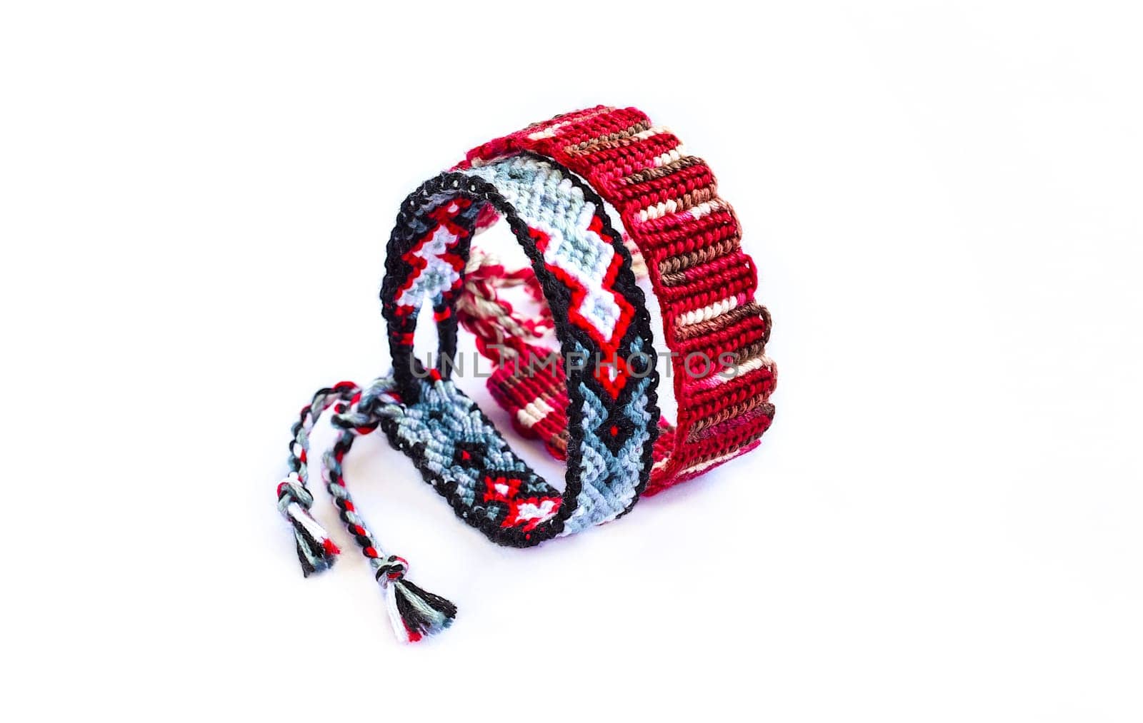 Multicolored woven DIY friendship bracelets handmade of embroidery bright thread with knots isolated on white background