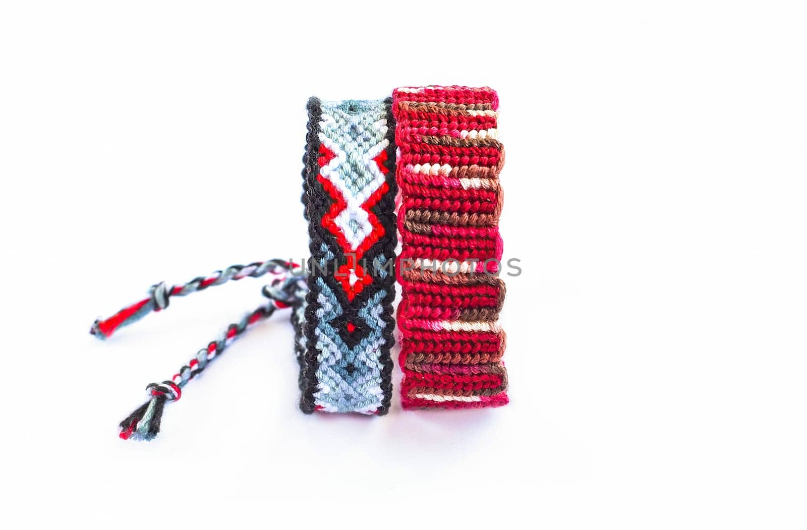 Multicolored woven DIY friendship bracelets handmade of embroidery bright thread with knots isolated on white background