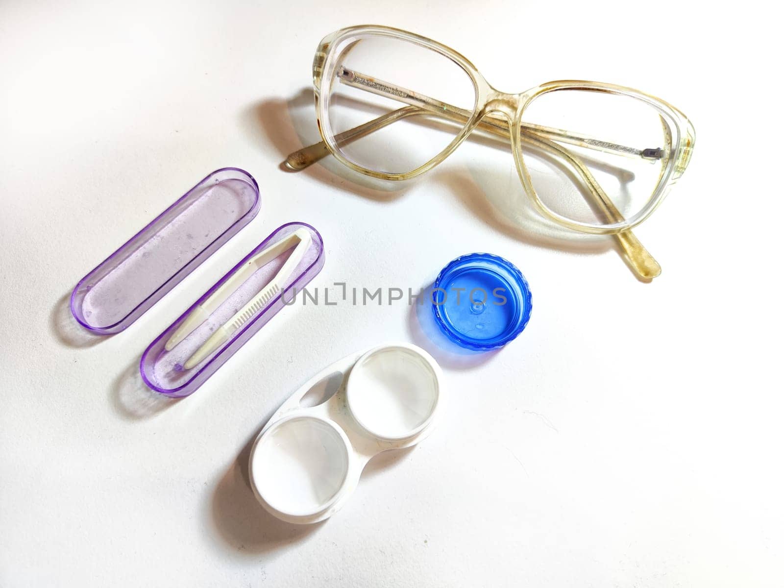 A pair of stylish glasses is sitting right next to a set of modern contact lenses, showcasing two popular eyewear options