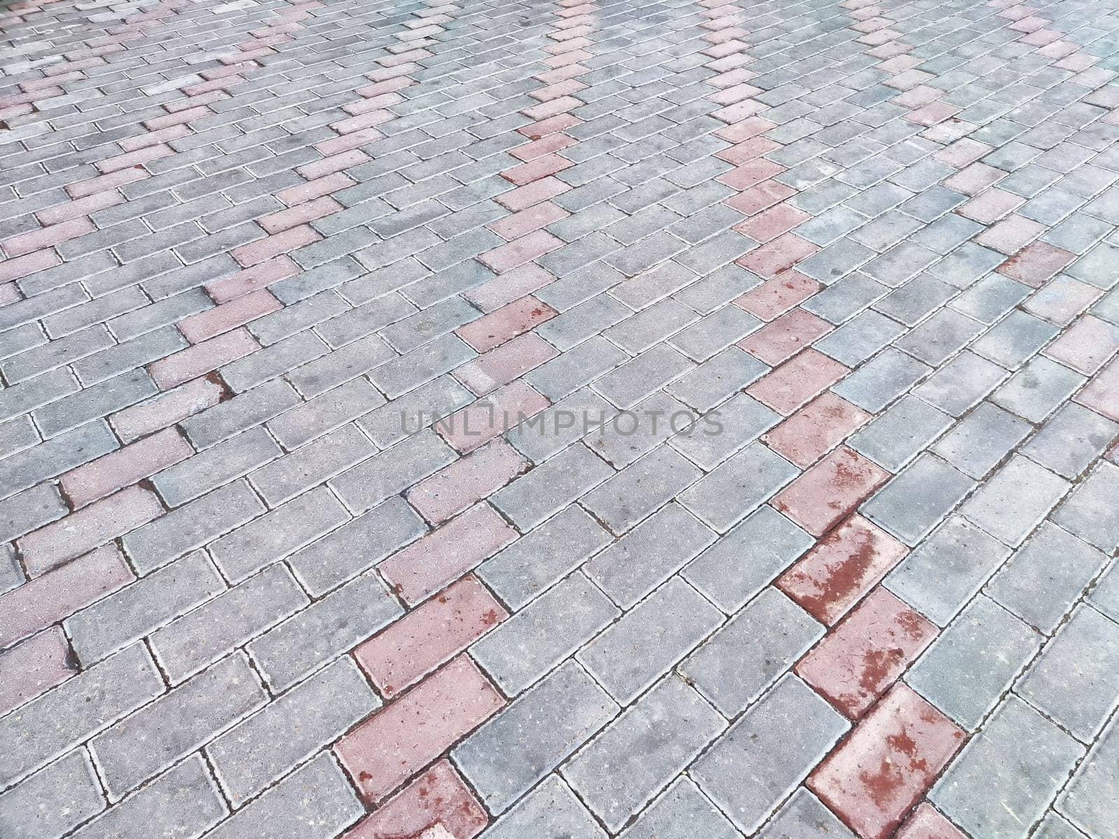 A patterned arrangement of paving stones creates a visually striking effect in a driveway.