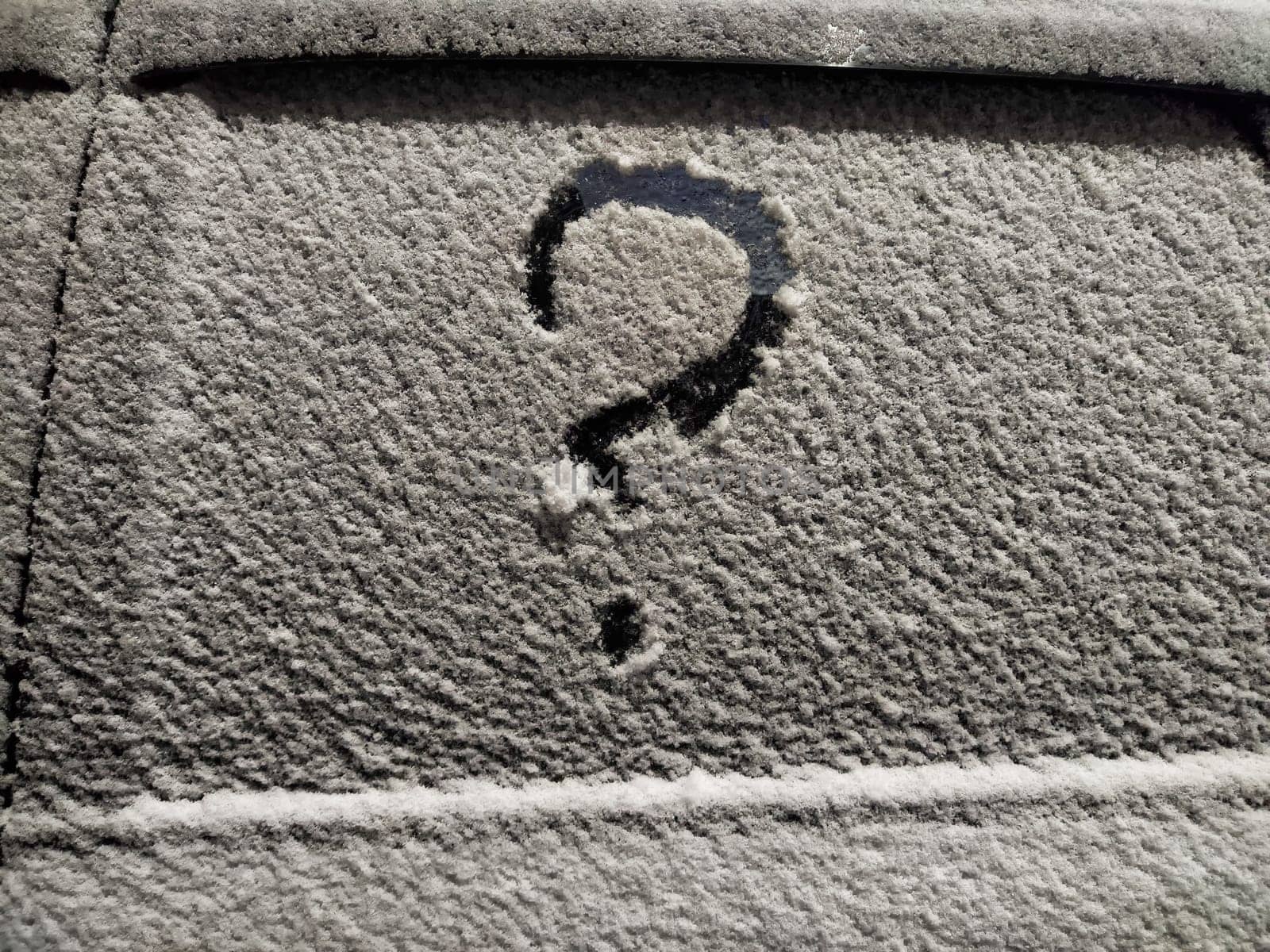 A question mark drawn on a frosted surface reflects feelings of insecurity and uncertainty in a business context during winter.