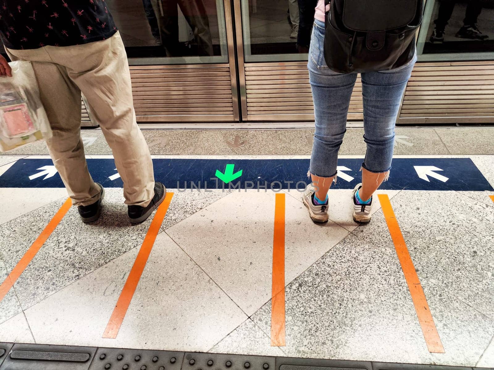 Hong Kong, China - April 09, 2024 - Commuters patiently stand at a subway platform in Hong Kong, waiting for the next train during busy hours.