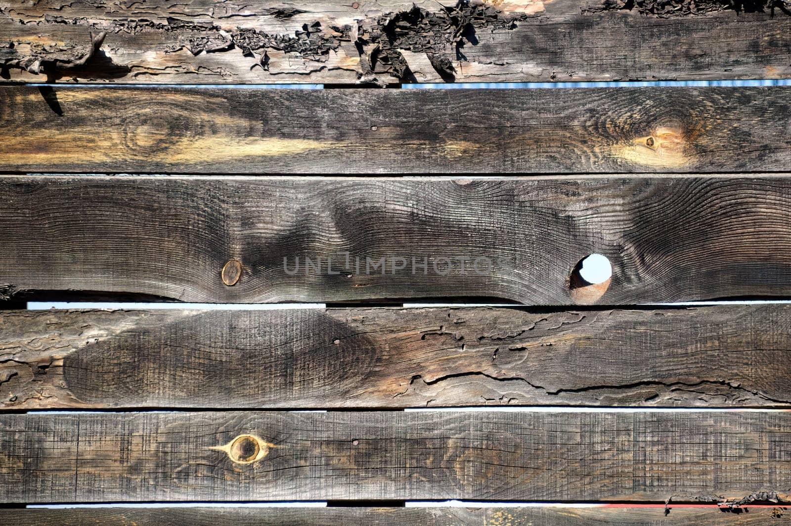 Wooden fence made of boards with holes. background
