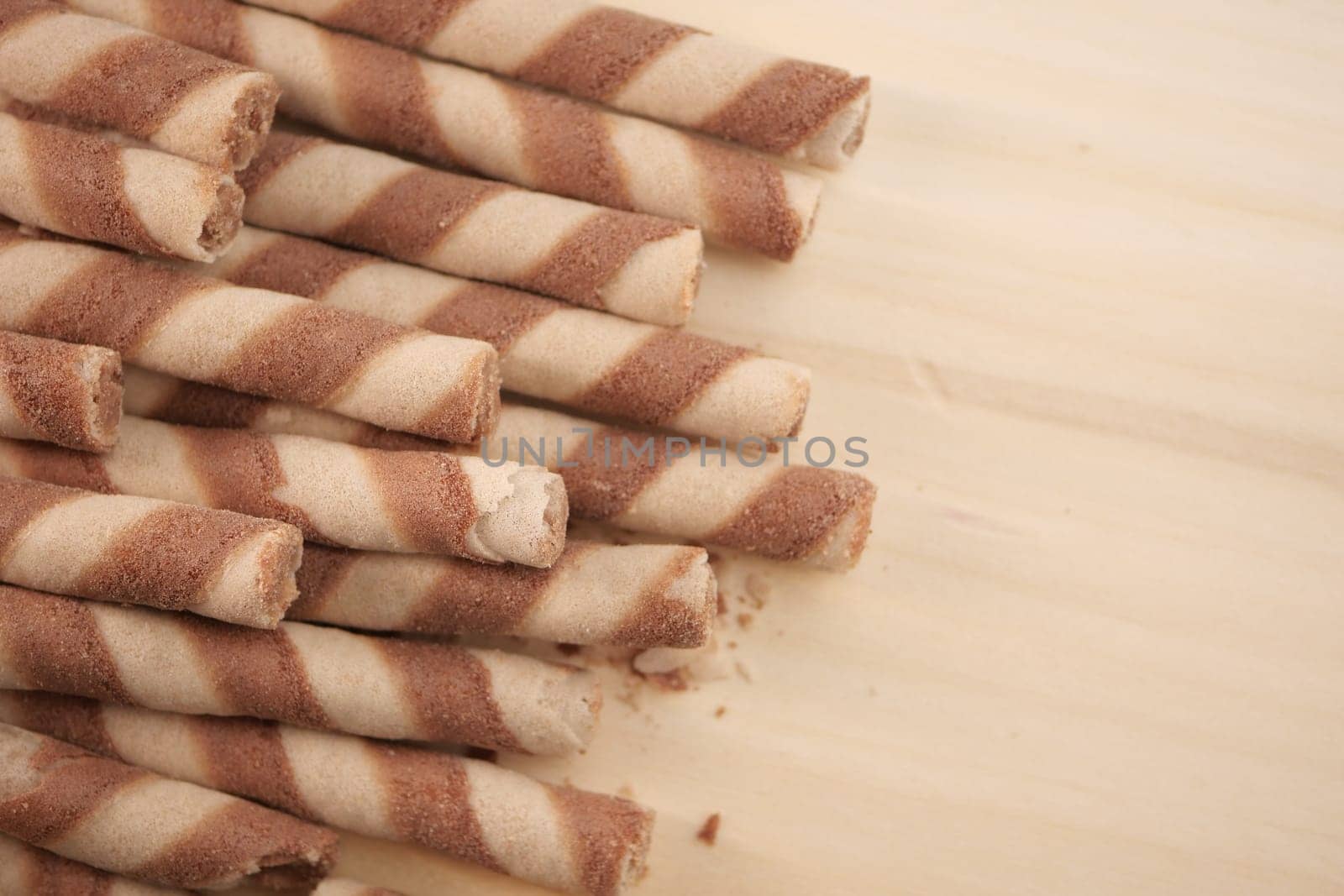 Crispy striped wafers arranged on a light wooden backdrop.