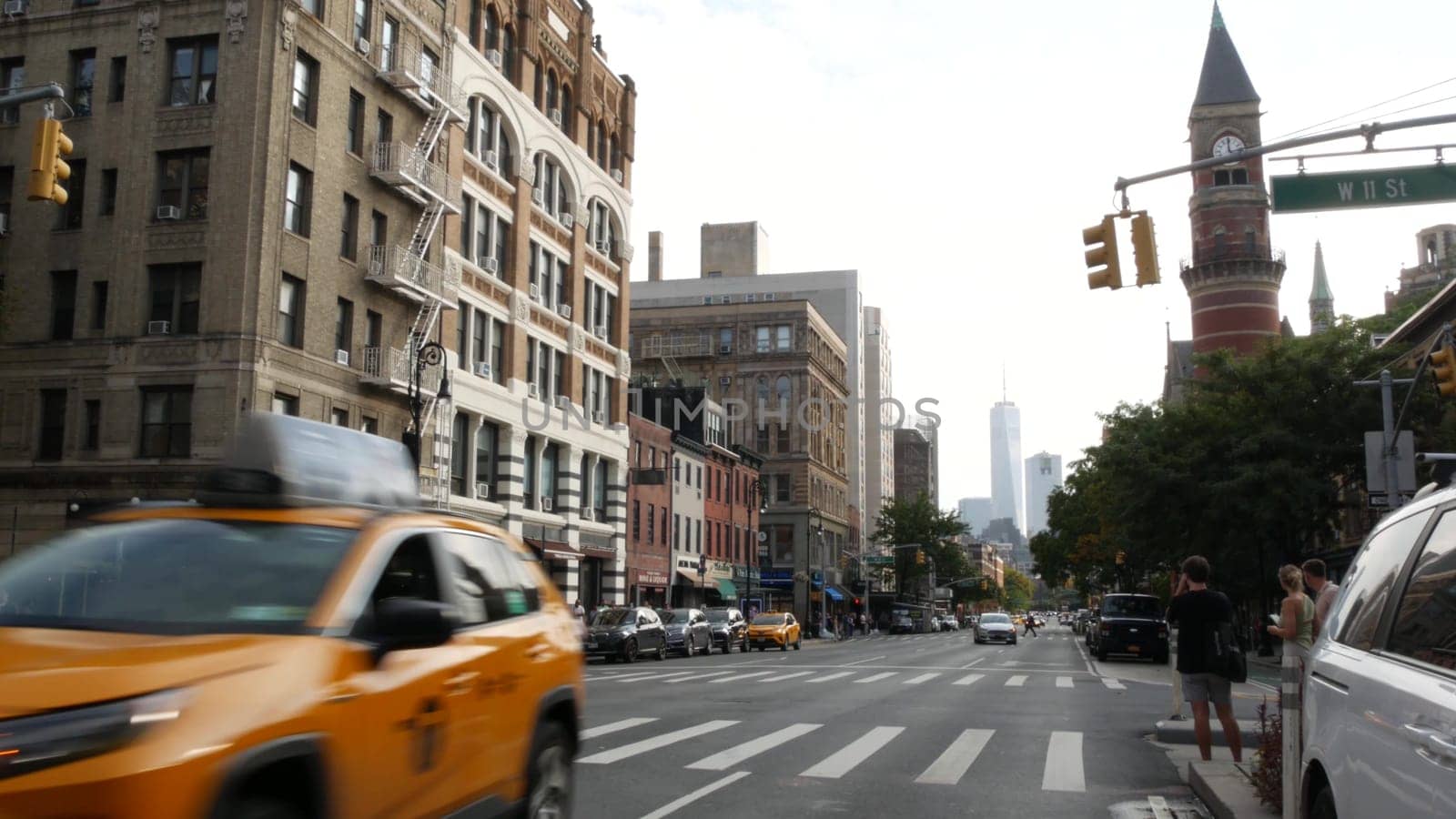 New York City, United States - 10 Sept 2023: Manhattan Greenwich Village street, Sixth 6 Americas avenue crossroad. Road traffic, yellow taxi. People, USA World trade center. Jefferson Market Library.