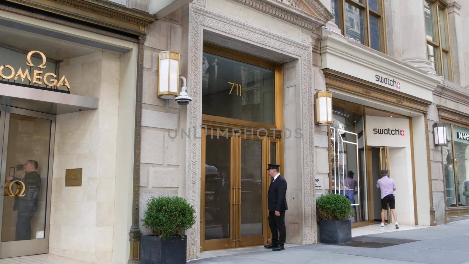New York City, United States - 11 Sept 2023: Manhattan Midtown street, Fifth 5 avenue. American urban scene, USA. People pedestrians on sidewalk pavement. Boutique stores for luxury fashion shopping.