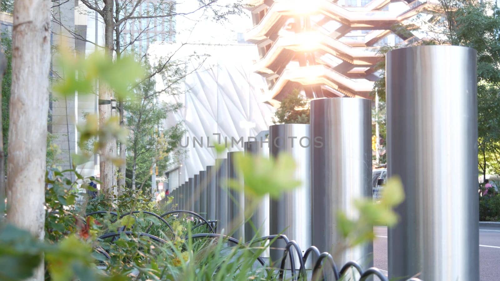 New York City, United States - 1 Sept 2023: Hudson Yards Vessel, urban architecture in Chelsea, Manhattan Midtown, NYC, USA. Street perspective, famous tourist landmark. Park greenery, sun reflection.