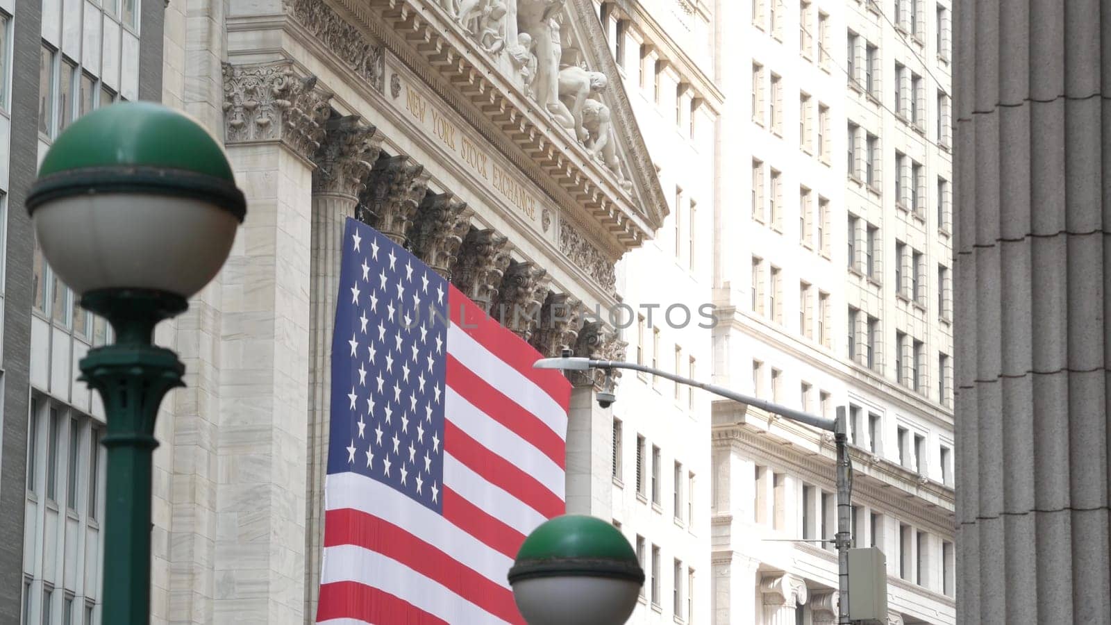New York City, United States - 9 Sept 2023: Manhattan Downtown Financial District urban architecture. Huge big American flag. Wall street Stock Exchange building, USA Stock Market. Subway orb globe.