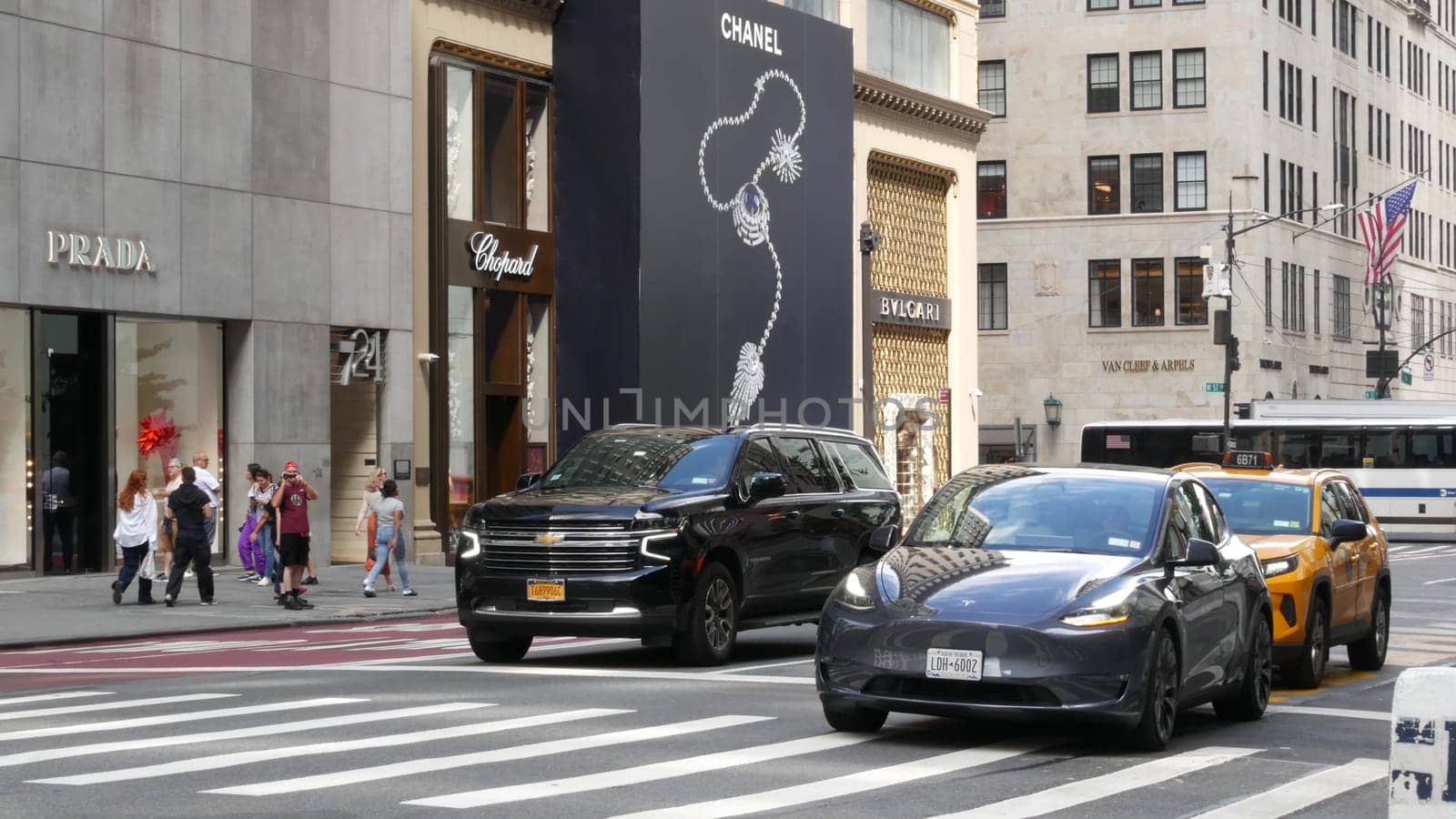 New York City, United States - 13 Sept 2023: Manhattan Midtown street, Fifth 5 avenue. American urban road car traffic. Yellow taxi in USA. People. Boutique fashion stores for shopping. Chanel, Prada.