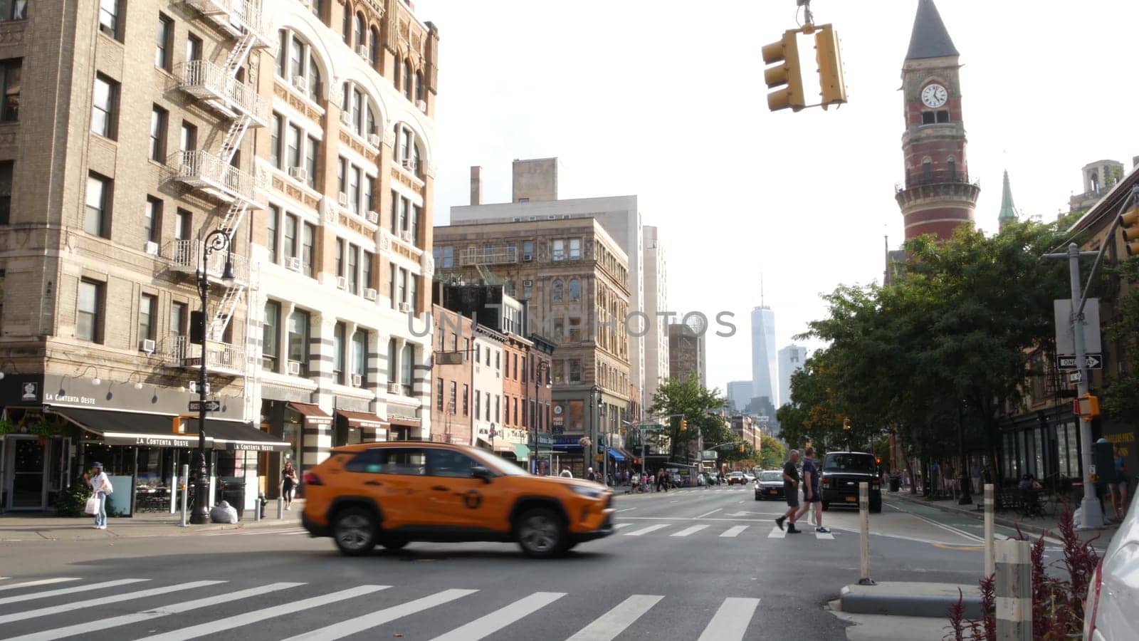 New York City, United States - 10 Sept 2023: Manhattan Greenwich Village street, Sixth 6 Americas avenue crossroad. Road traffic, yellow taxi. People, USA World trade center. Jefferson Market Library.
