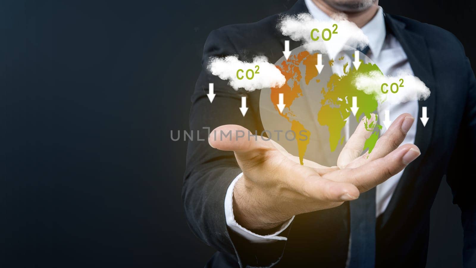 The business hand shows a virtual earth with a sign of carbon reduction for decreased CO2. Concepts of environmental protection, climate change, global warming, or net zero carbon neutral