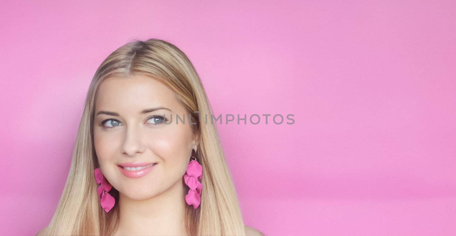 Woman, pink background and subtle smile, blonde hair with vibrant pink floral earrings. Feminine charm, radiant beauty and effortless elegance look