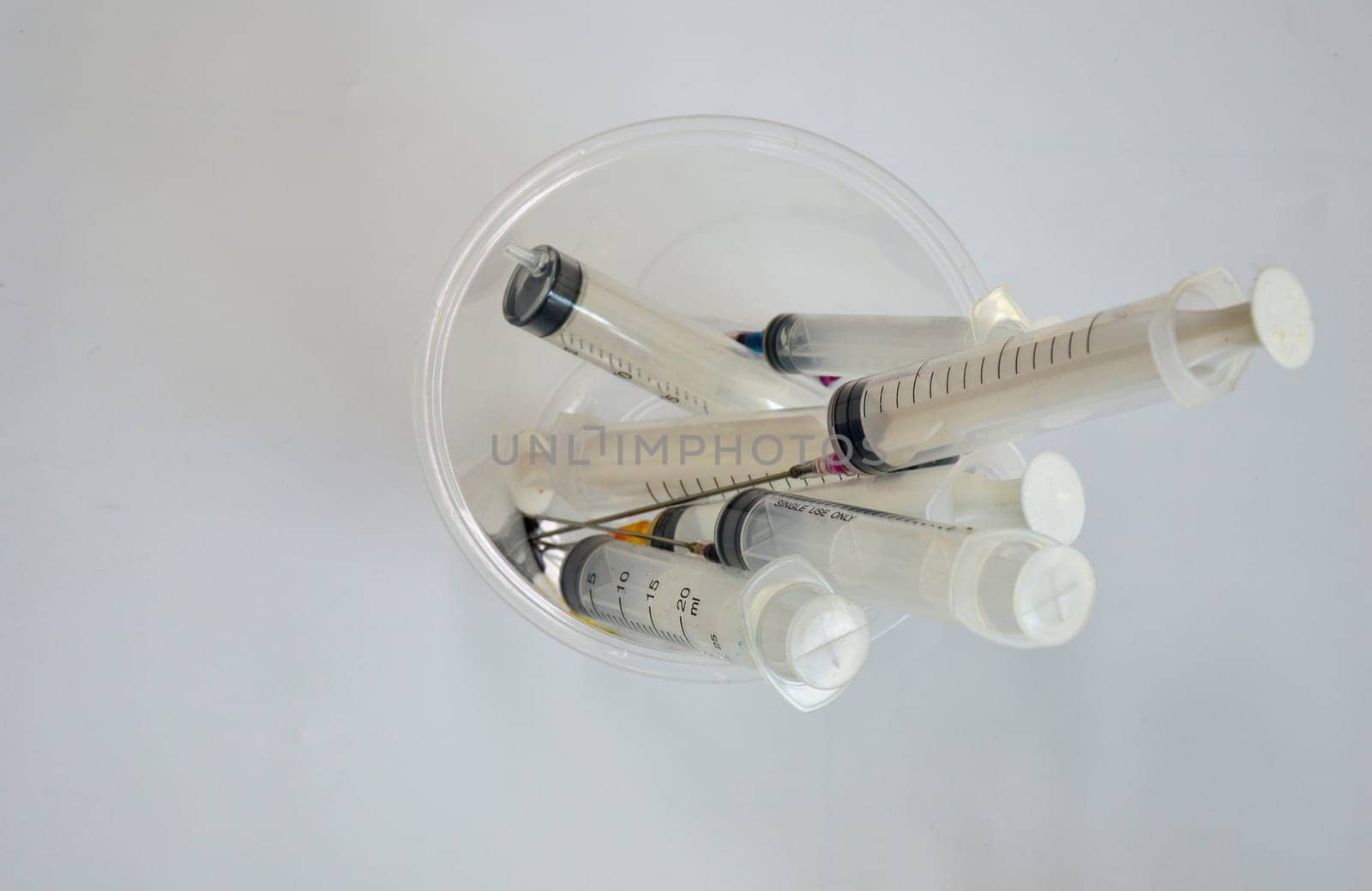 used syringes put in a clear white container