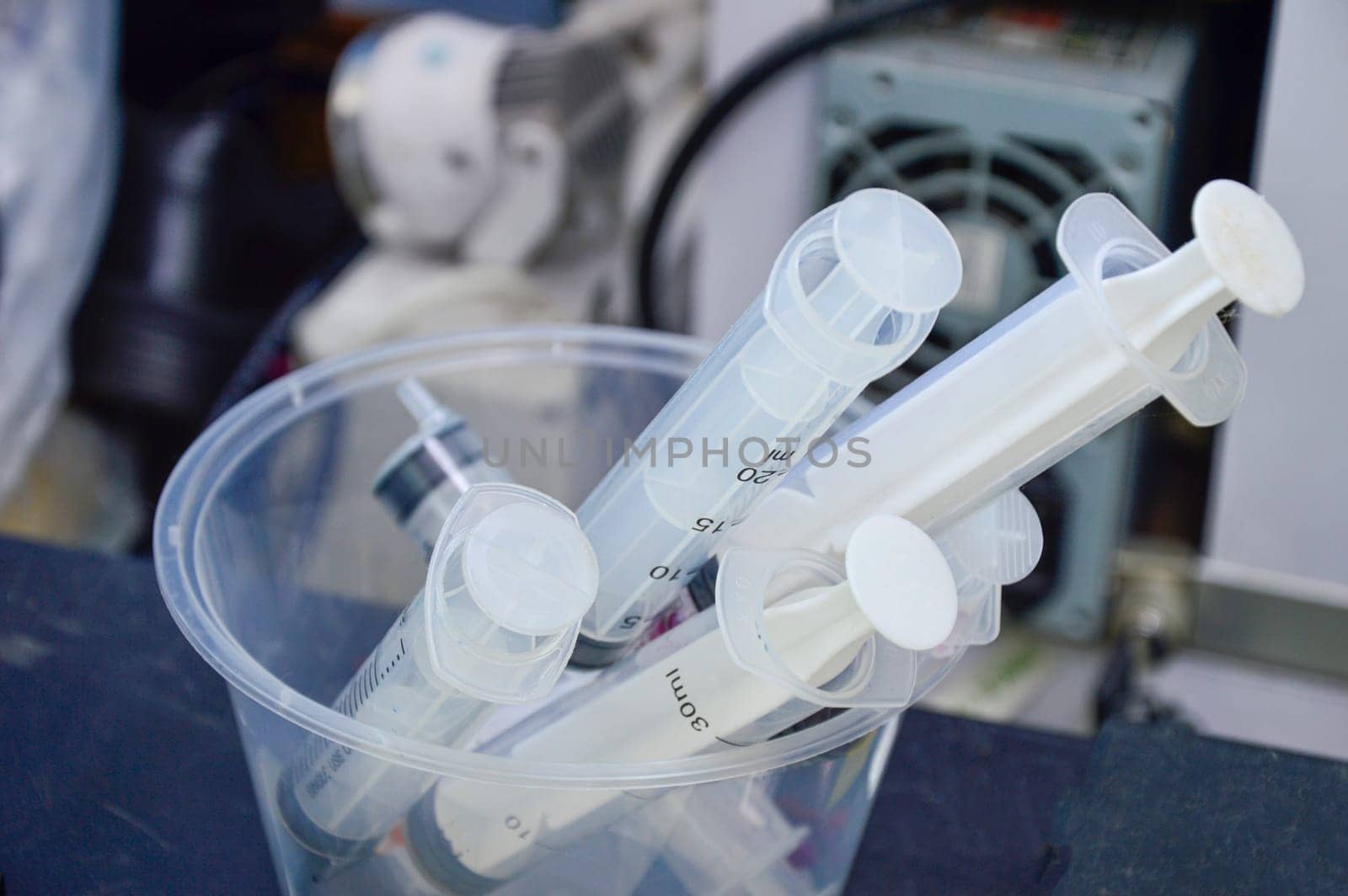 used syringes put in a clear white container