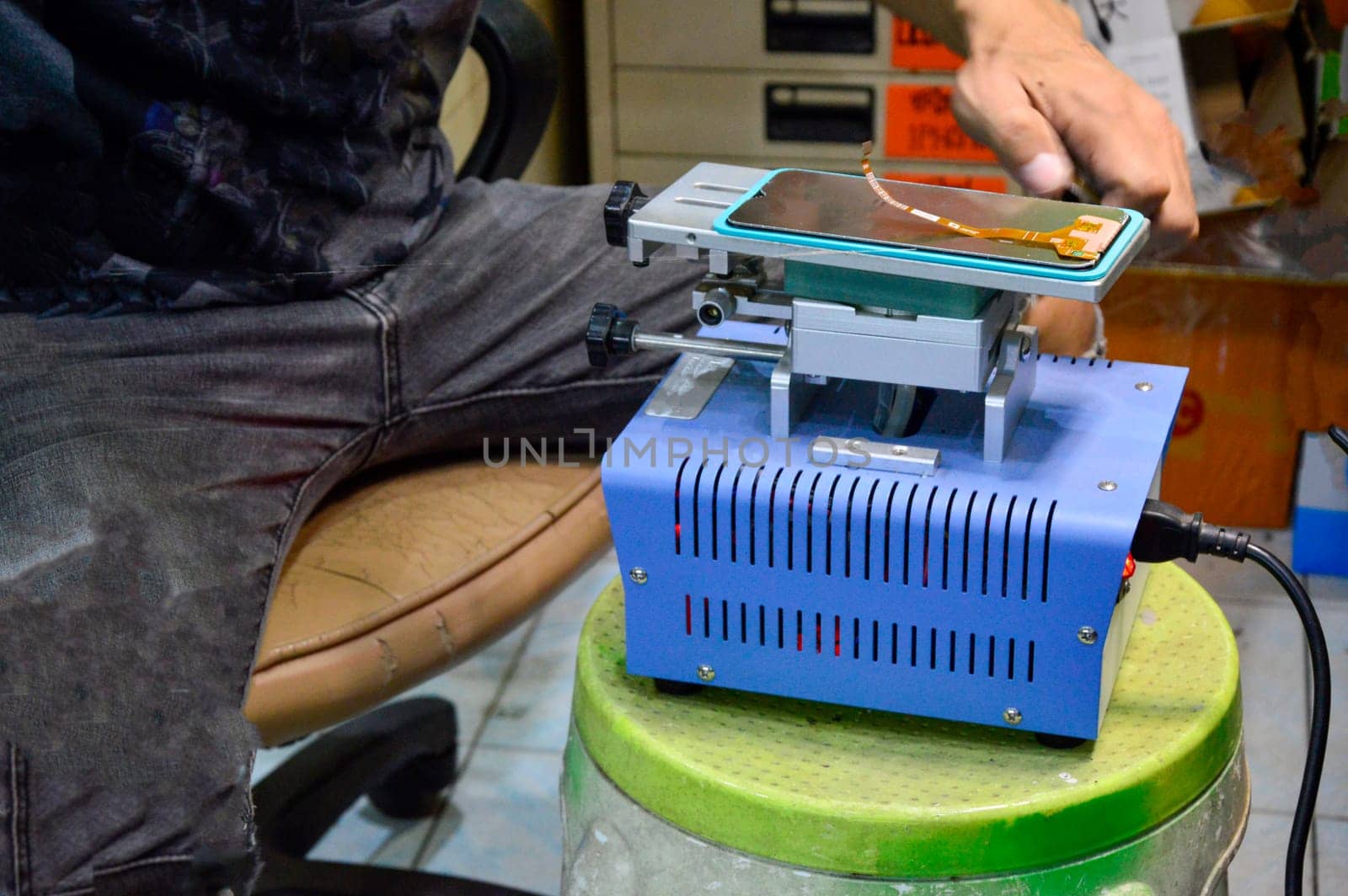 Image of a technician repairing a mobile phone screen. by boonruen