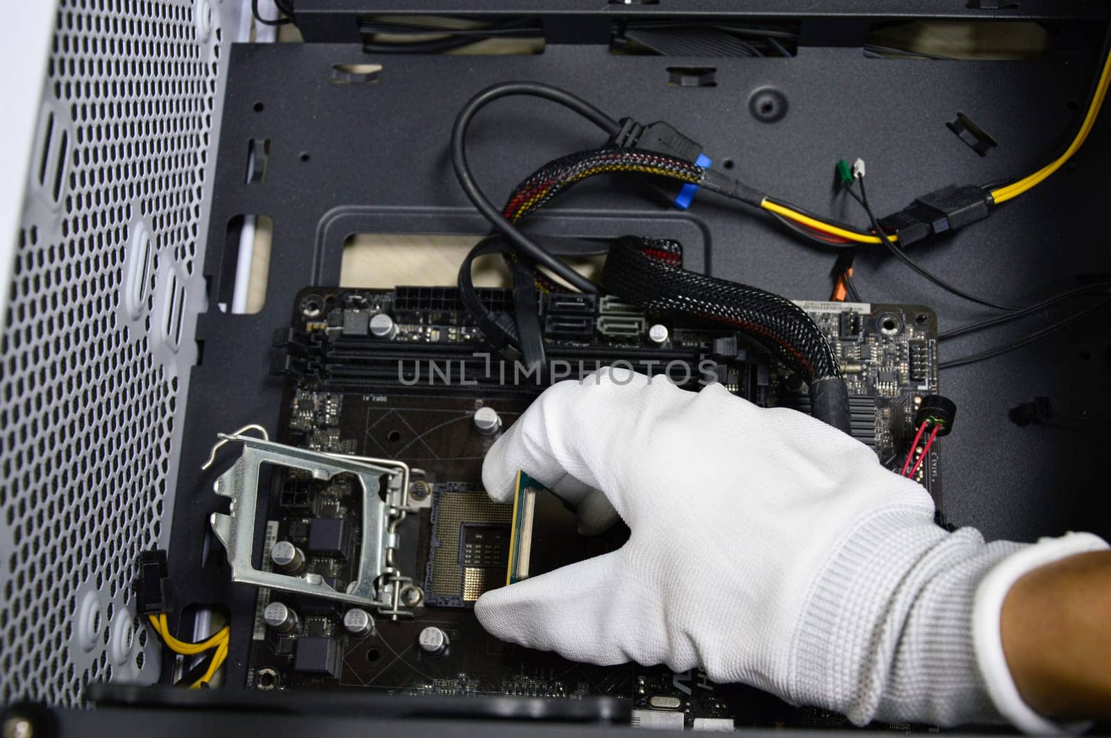 Image of a technician inserting a CPU chip onto a computer motherboard.