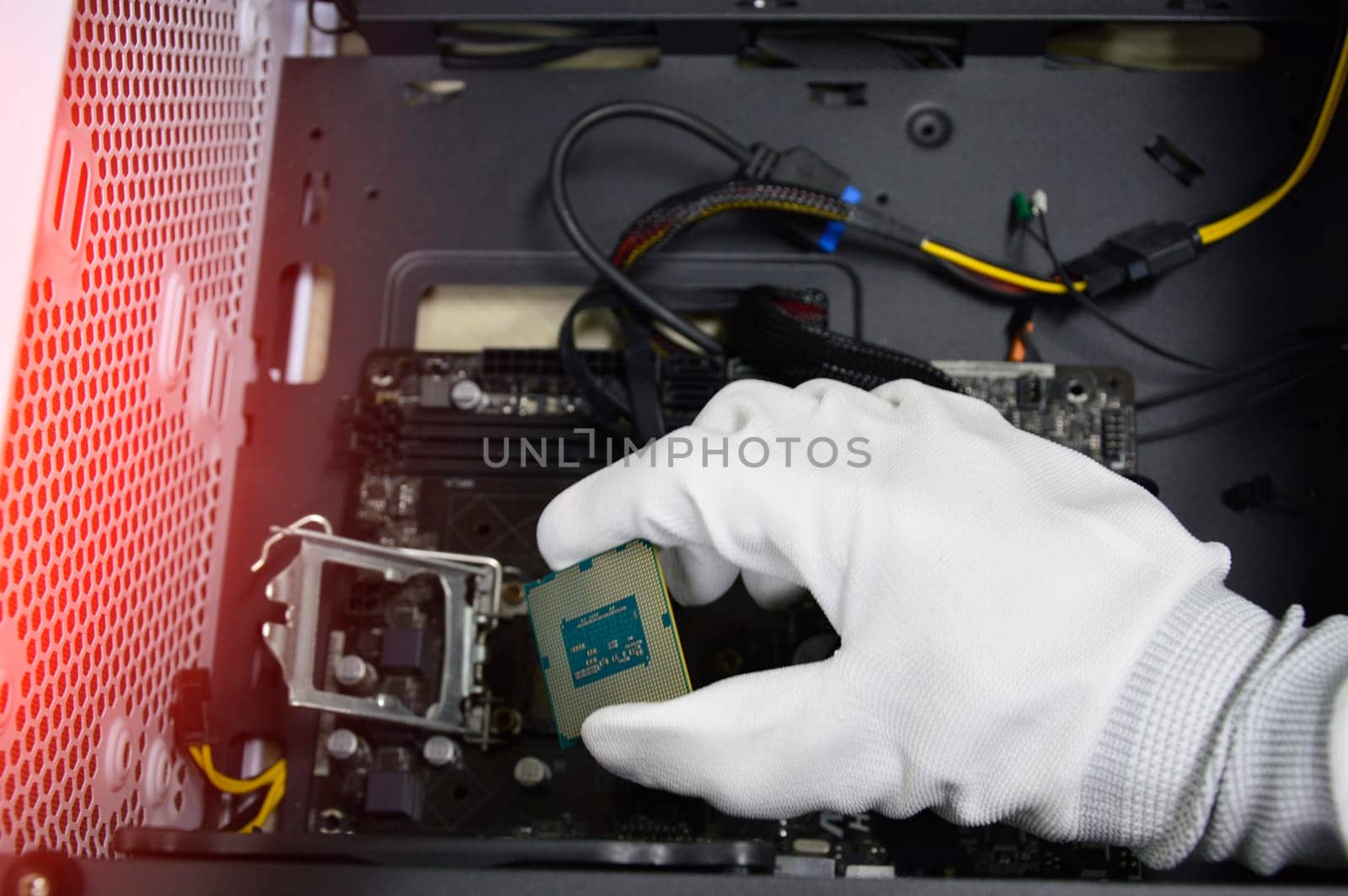 Image of a technician inserting a CPU chip onto a computer motherboard.