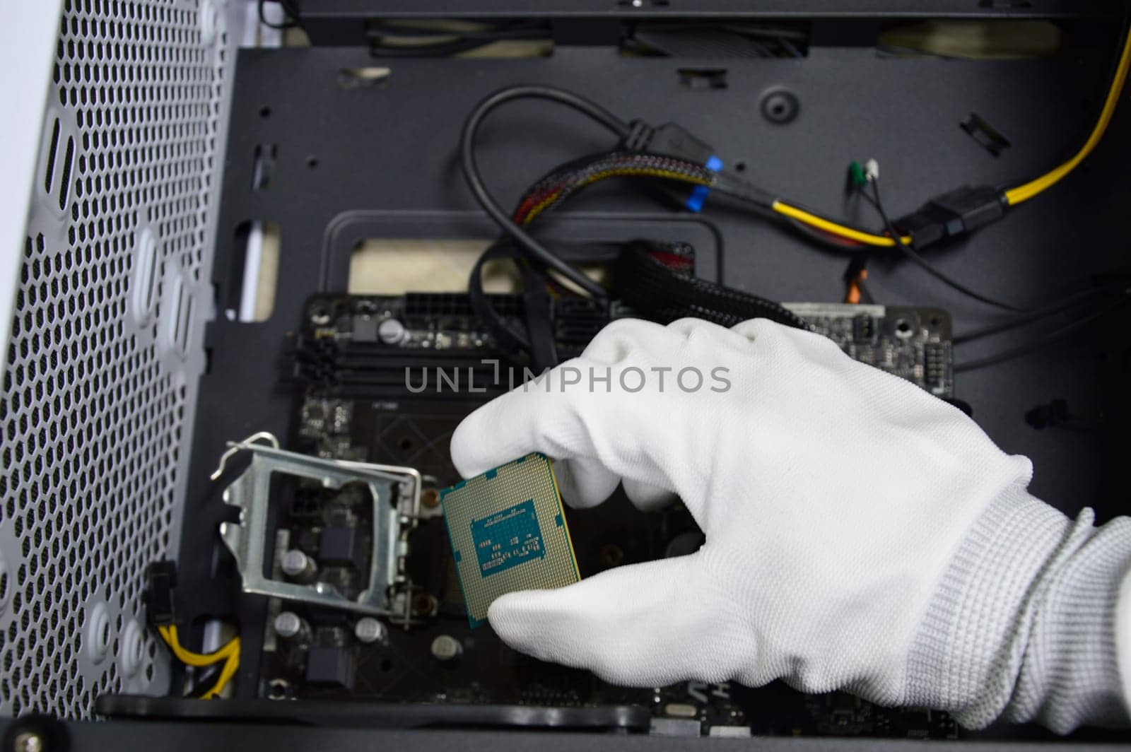 Image of a technician inserting a CPU chip onto a computer motherboard.