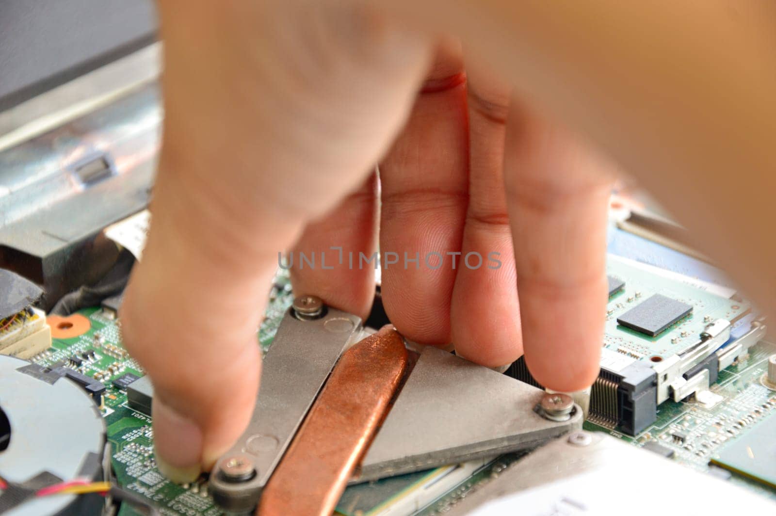 Close-up of the hand about to put the device on the motherboard.