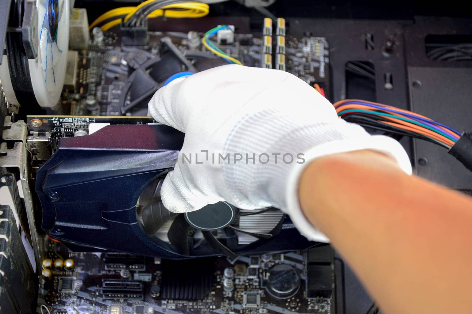 Top view technician about to install, black graphics card in hand.