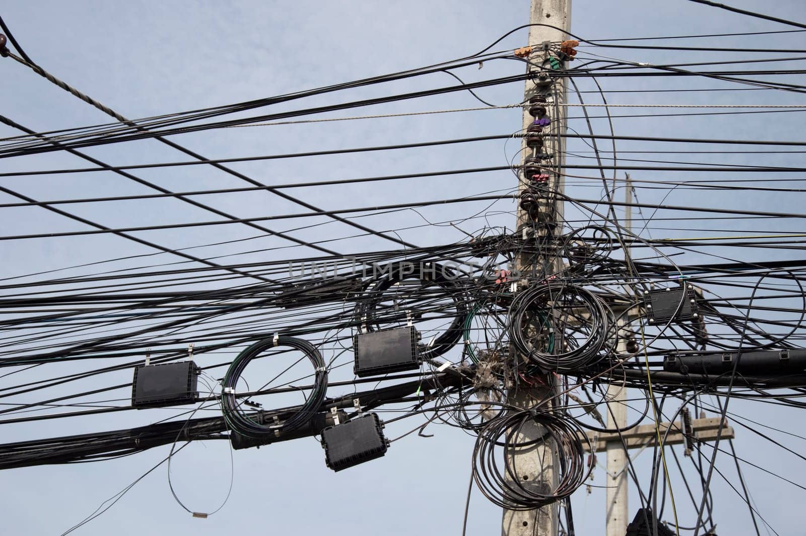 The image of the wires installed on the poles is very cluttered and tangled. by boonruen