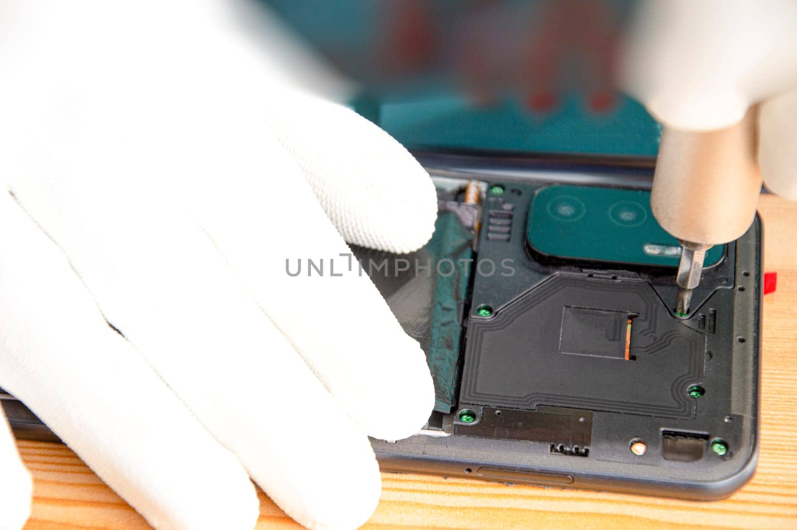 Image of a technician screwing the back of a mobile phone