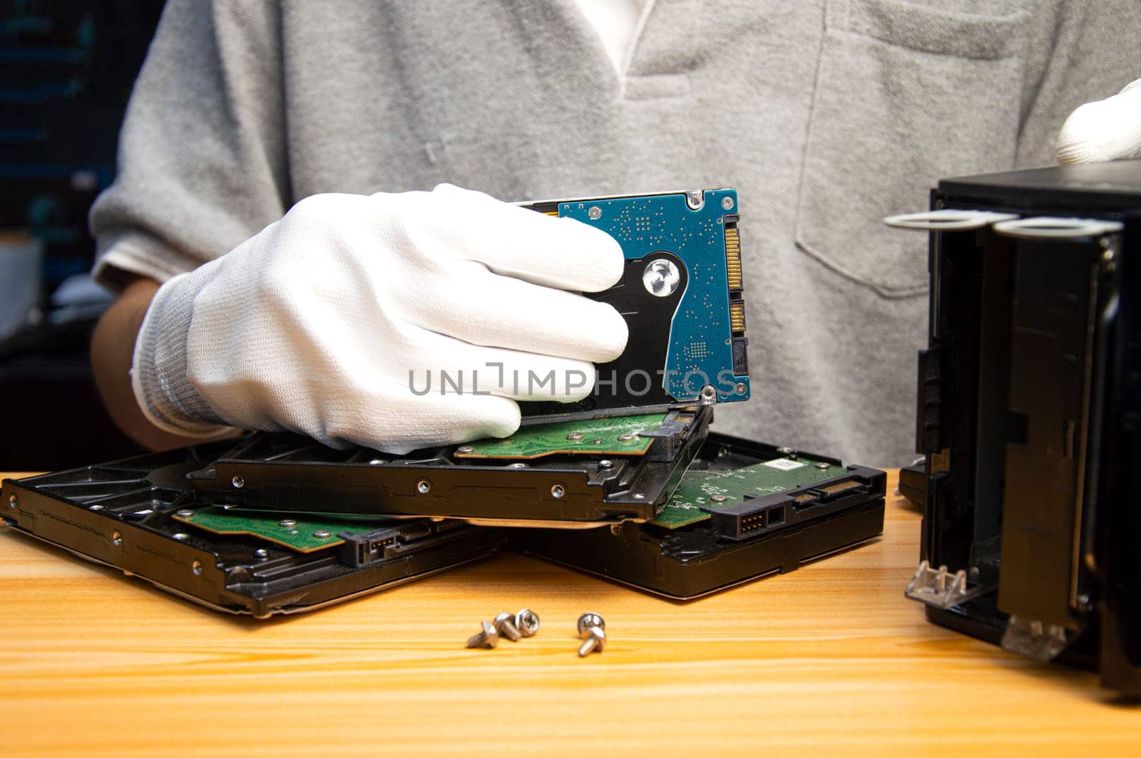 2.5-inch hard drives are still popular today, technician holding a hard drive in hand by boonruen