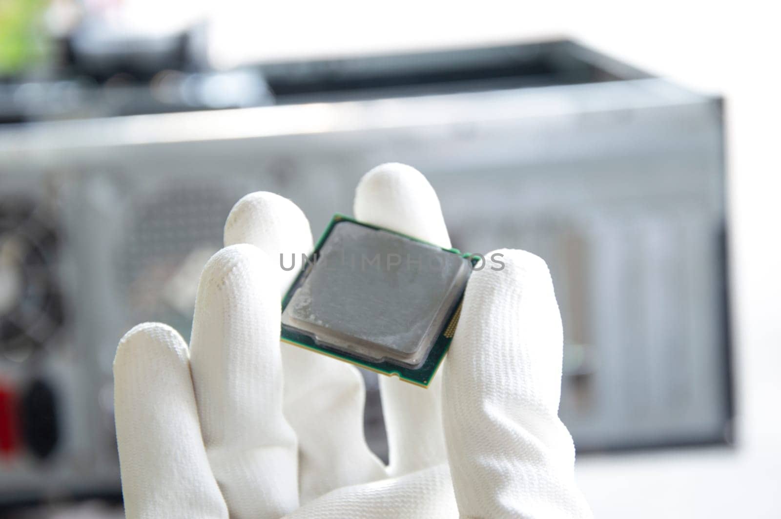 An image of a technician holding a CPU in his hand.
